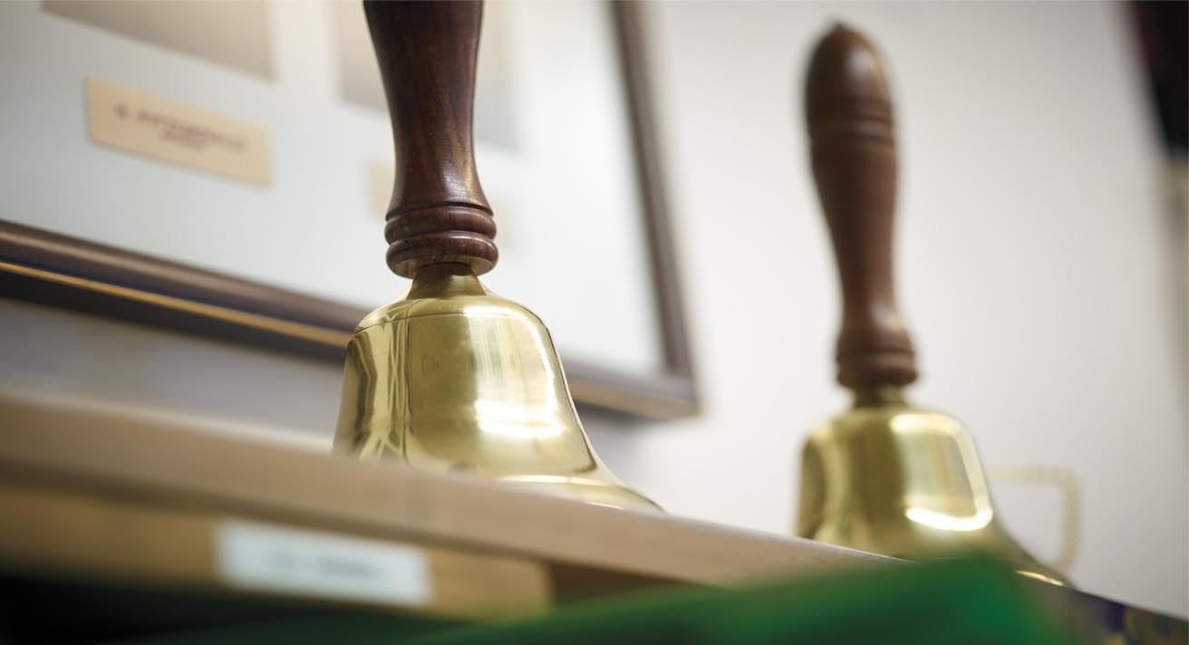 Two old-fashioned hand bells sit on a desk